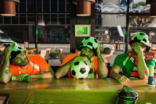 Fußballfan sitzt mit Ball und guckt Spiel mit Freunden — Stockfoto