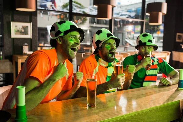 Les fans de football regardent le match et acclament dans le bar — Photo de stock
