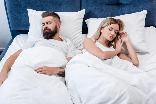 Homem barbudo e menina atraente dormindo na cama branca — Fotografia de Stock