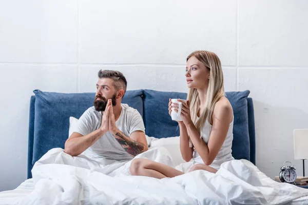 Молодая пара пьет кофе в белой кровати утром — стоковое фото