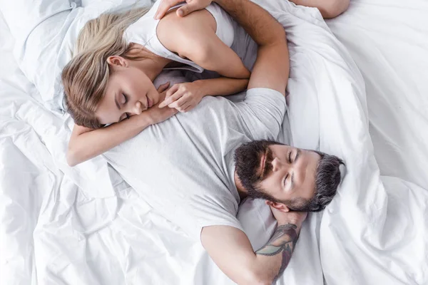 Bella ragazza mettere testa su bello uomo petto e dormire a letto — Foto stock