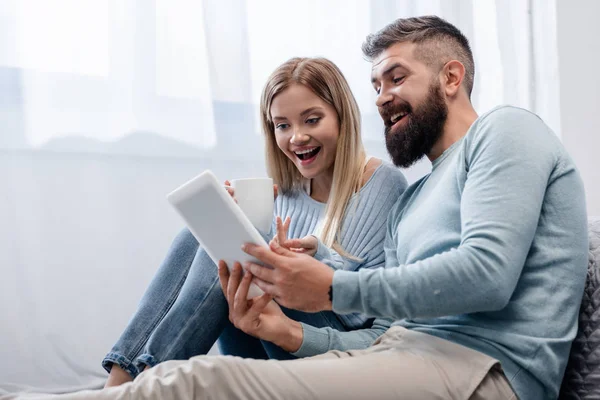 Casal em roupas casuais usando tablet digital — Fotografia de Stock