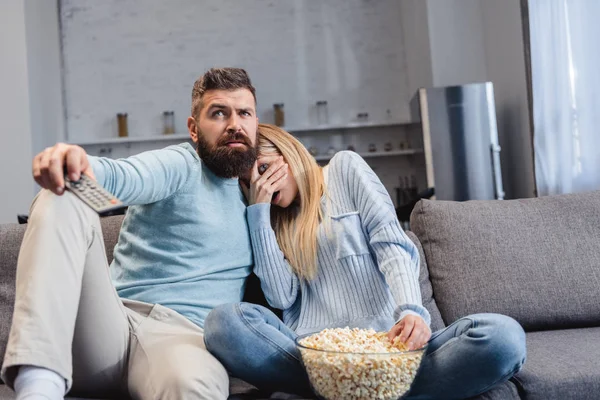 Paar sitzt mit Popcorn und schaut Gruselfilm — Stockfoto