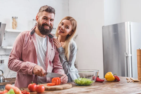 Casal sorridente preparando jantar na cozinha — Fotografia de Stock