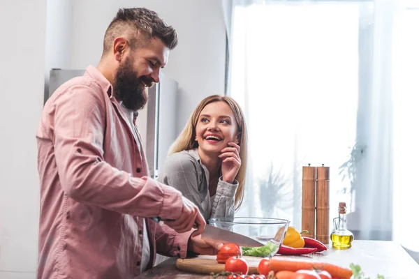 Cheerful couple cooking together in kitchen — Stock Photo