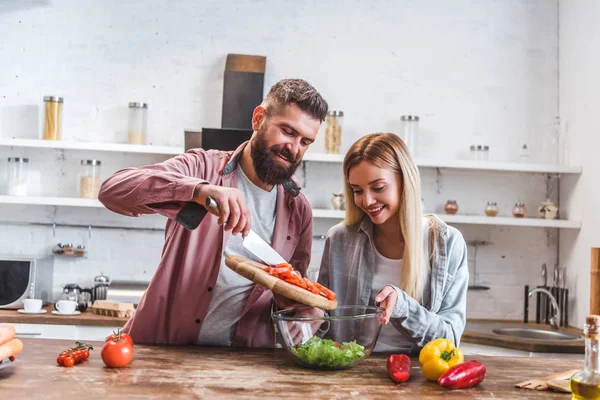 Mann und Frau fügen Zutaten in Salat hinzu — Stockfoto