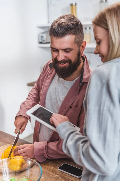 Esposa segurando tablet digital e marido olhando para tela em branco — Fotografia de Stock