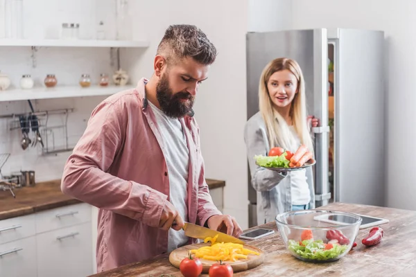 Jovem esposa e marido barbudo cozinhar jantar juntos — Fotografia de Stock