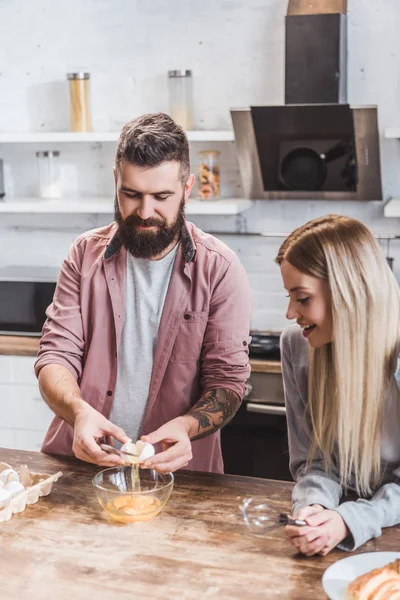 Молода пара готує сніданок разом на кухні — стокове фото