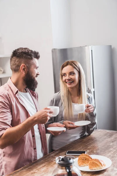 Sorrindo casal tomando café da manhã juntos na cozinha — Fotografia de Stock