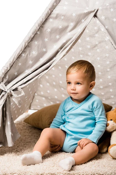 Niño sentado en wigwam bebé con almohada y oso de peluche aislado en blanco - foto de stock