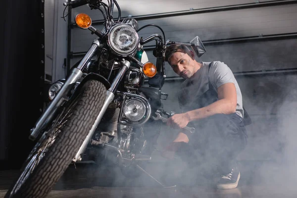 Mechaniker fixiert Motorrad-Vorderrad in Garage — Stockfoto