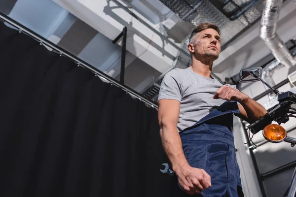 Vue du bas du mécanicien avec clé dans le garage — Photo de stock