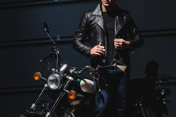 Cropped view of guy standing by motorcycle in garage — Stock Photo