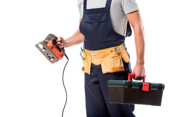 Vista recortada de carpintero sosteniendo sierra eléctrica y caja de herramientas aislada en blanco - foto de stock