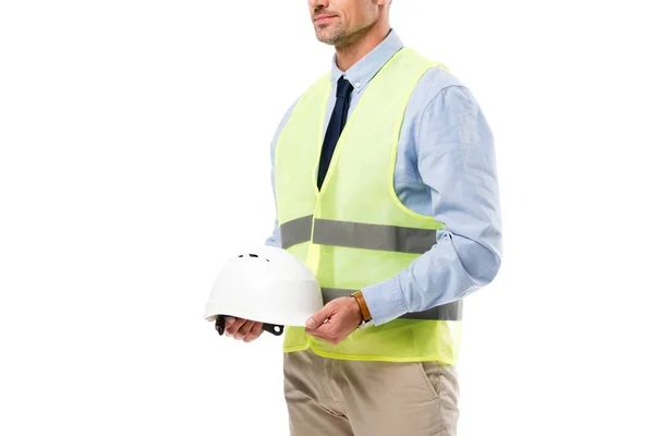 Vista cortada de engenheiro em colete de segurança segurando capacete isolado no branco — Fotografia de Stock