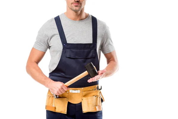 Partial view of worker in overalls holding hammer isolated on white — Stock Photo