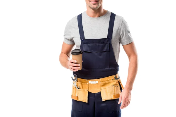 Partial view of worker with tool belt drinking coffee to go isolated on white — Stock Photo