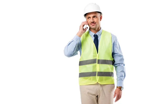 Ingeniero guapo en casco hablando en teléfono inteligente aislado en blanco - foto de stock
