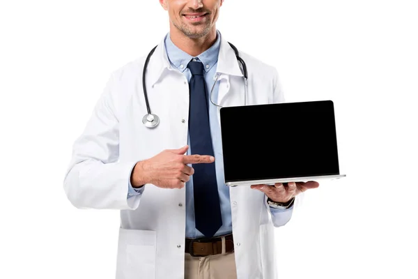Cropped view of doctor pointing finger at laptop with blank screen isolated on white — Stock Photo