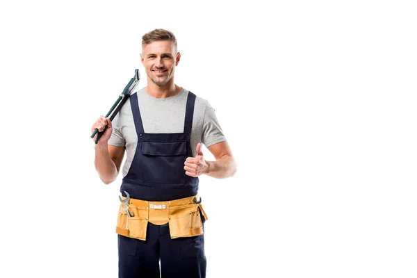 Lächelnder Installateur hält Rohrschlüssel in der Hand und zeigt Daumenhoch-Zeichen isoliert auf weiß — Stockfoto