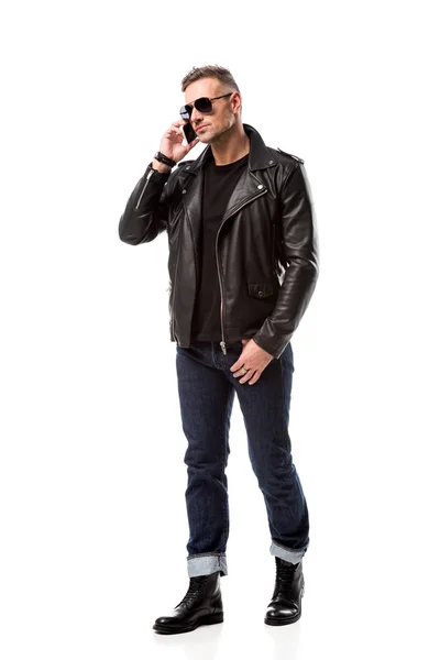 Hombre guapo serio en gafas de sol hablando en el teléfono inteligente aislado en blanco - foto de stock