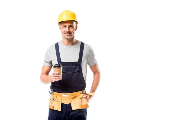 Smiling construction worker in helmet drinking coffee to go isolated on white — Stock Photo