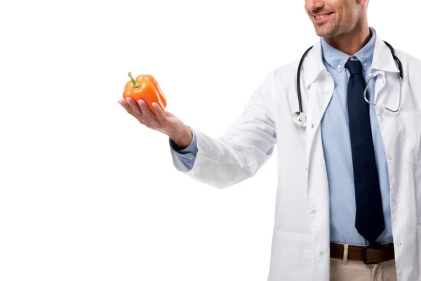 Abgeschnittene Ansicht eines Arztes, der Paprika isoliert auf weißem, gesundem Ernährungskonzept hält — Stockfoto