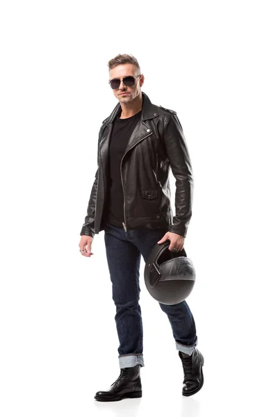 Homem bonito em jaqueta de couro e óculos de sol segurando capacete de motocicleta isolado no branco — Fotografia de Stock