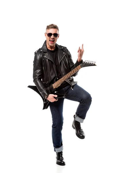 Hombre con estilo excitado en chaqueta de cuero sosteniendo la guitarra eléctrica y mostrando el cartel de rock aislado en blanco - foto de stock