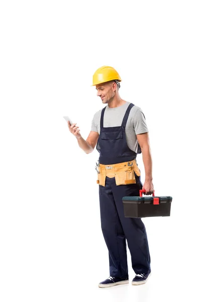 Trabajador de la construcción en casco usando teléfono inteligente aislado en blanco - foto de stock