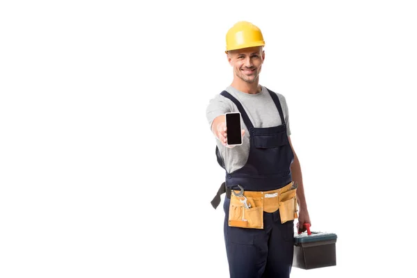 Trabajador de la construcción en sombrero duro presentando teléfono inteligente con pantalla en blanco aislado en blanco - foto de stock
