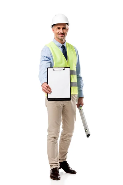 Smiling engineer holding clipboard with blank sheet and spirit level isolated on white — Stock Photo