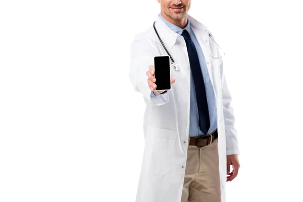 Vista recortada del médico sosteniendo smartphone con pantalla en blanco aislado en blanco - foto de stock