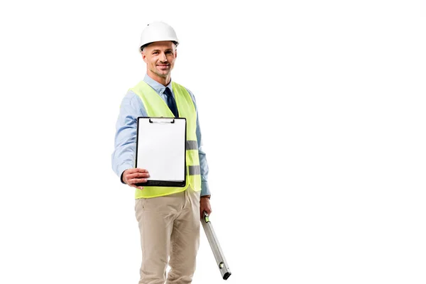 Handsome engineer holding clipboard with blank sheet and spirit level isolated on white — Stock Photo