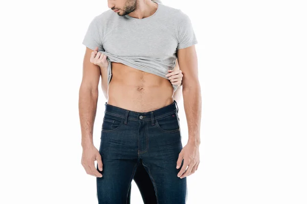Vista recortada de la mujer quitándose la camiseta de hombre aislado en blanco - foto de stock
