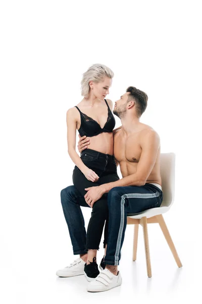 Beautiful couple sitting on chair and looking at each other isolated on white — Stock Photo