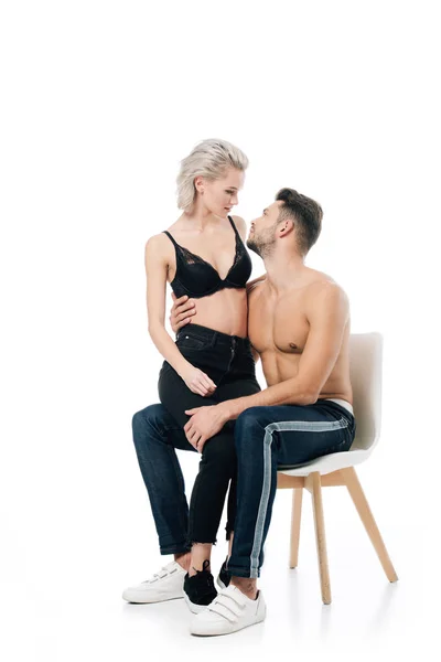 Beau couple assis sur chaise et regardant l'autre isolé sur blanc — Photo de stock