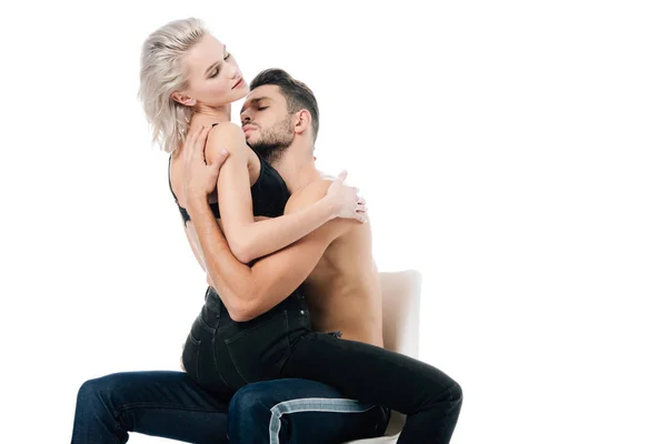 Hermosa pareja apasionada sentado en la silla y abrazo aislado en blanco - foto de stock