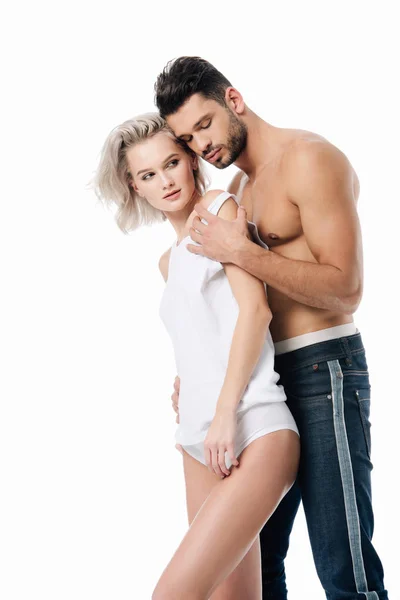 Muskulöser Mann umarmt schöne junge Frau isoliert auf weiß — Stockfoto