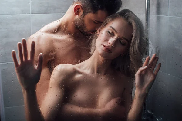 Homem bonito apaixonadamente abraçando mulher atraente no chuveiro — Fotografia de Stock