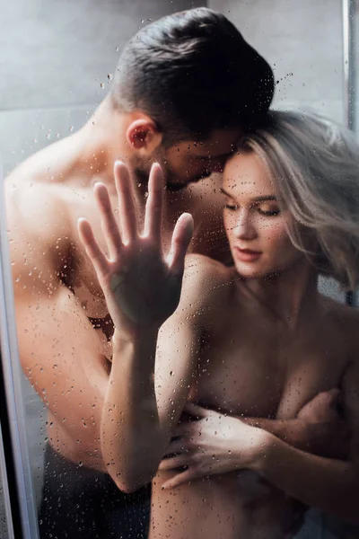 Apasionado hombre abrazando hermosa mujer en ducha - foto de stock