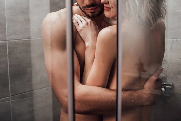 Vue recadrée de couple nu embrassant dans la passion et prenant une douche ensemble — Photo de stock