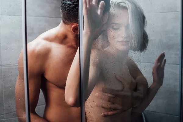Bonito homem apaixonadamente abraçando e segurando mulher no chuveiro — Fotografia de Stock