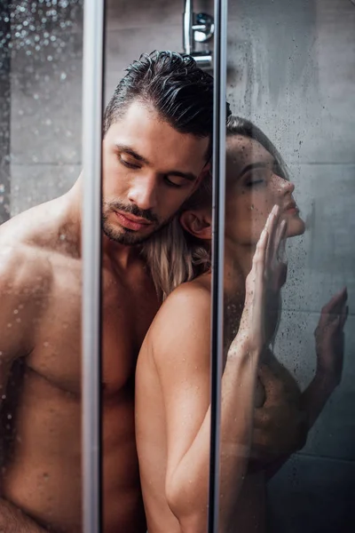 Beau couple nu embrassant dans la passion et prendre une douche ensemble — Photo de stock