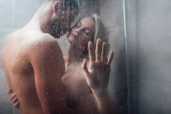 Uomo affettuoso con passione abbracciando bella donna sotto la doccia — Foto stock