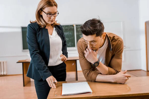 Ernsthafte Lehrerin und männliche Schülerin während der Prüfung im Klassenzimmer — Stockfoto