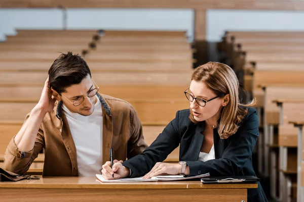 Insegnante di sesso femminile verifica i risultati dell'esame di studente maschio in classe — Foto stock