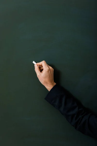 Cropped view of female teacher writing on green chalkboard — Stock Photo