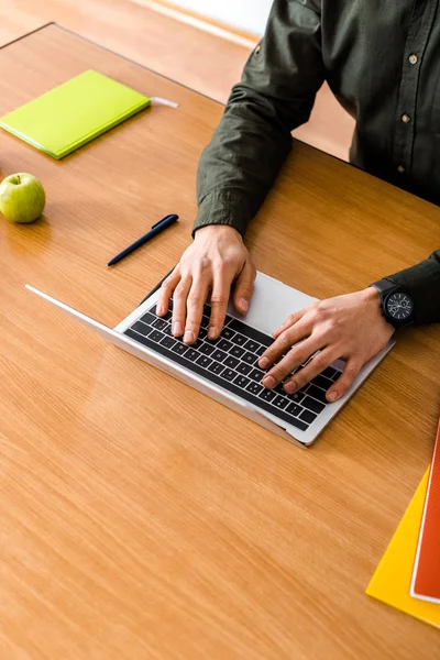 Vista parcial del estudiante masculino usando el ordenador portátil en el escritorio con espacio de copia - foto de stock
